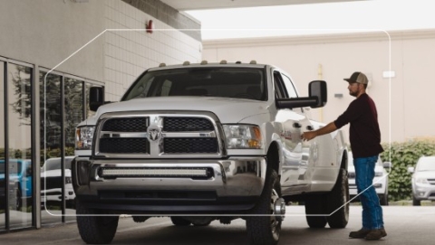Man getting in white Ram truck